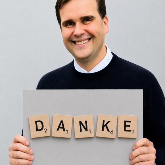 Pfarrer Detlef Pötzl hält ein Schild mit der Aufschrift Danke in den Händen.