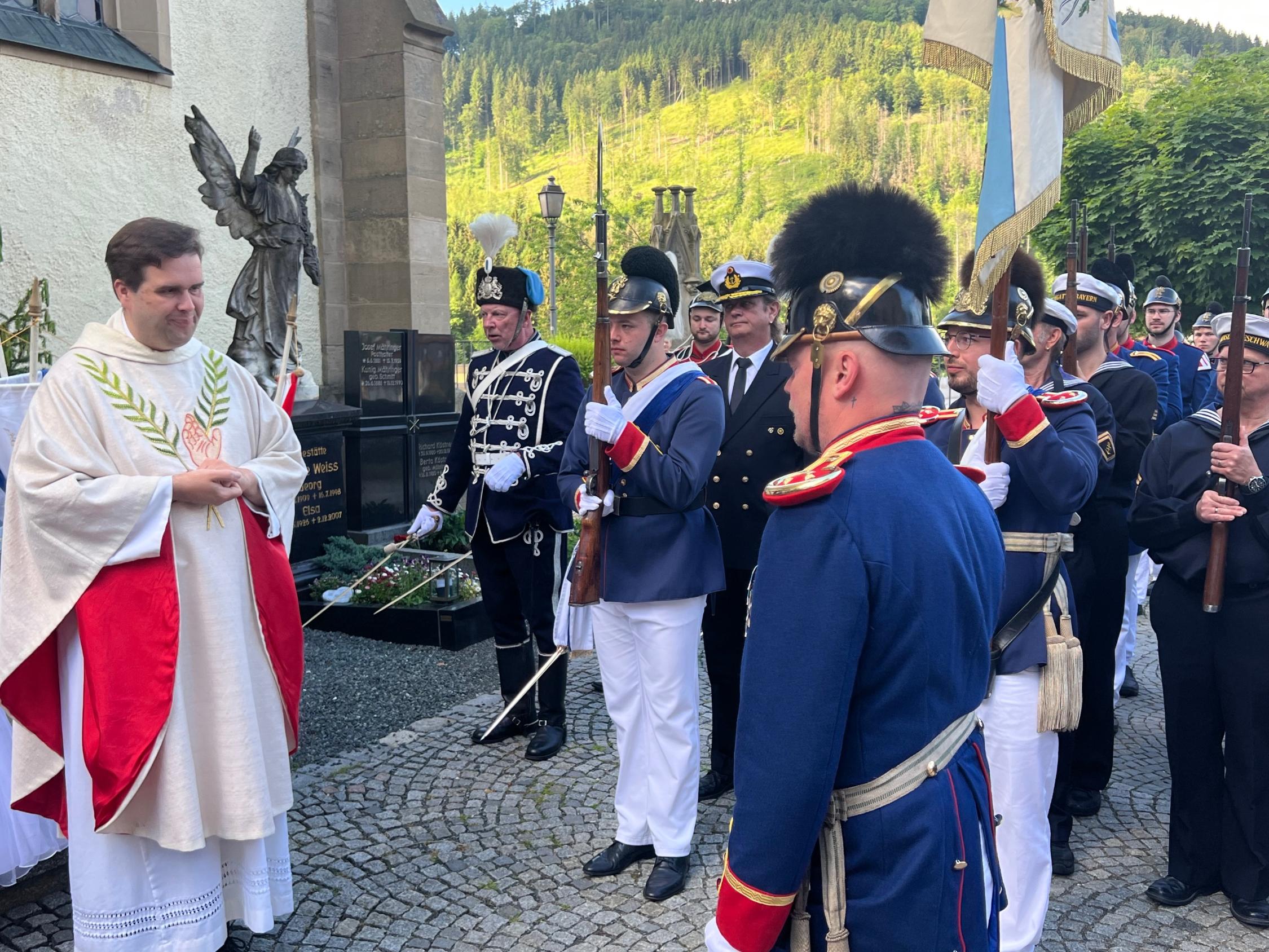 Pfarrer Pötzl begrüßt den Kommandanten Christopher Zeuß.